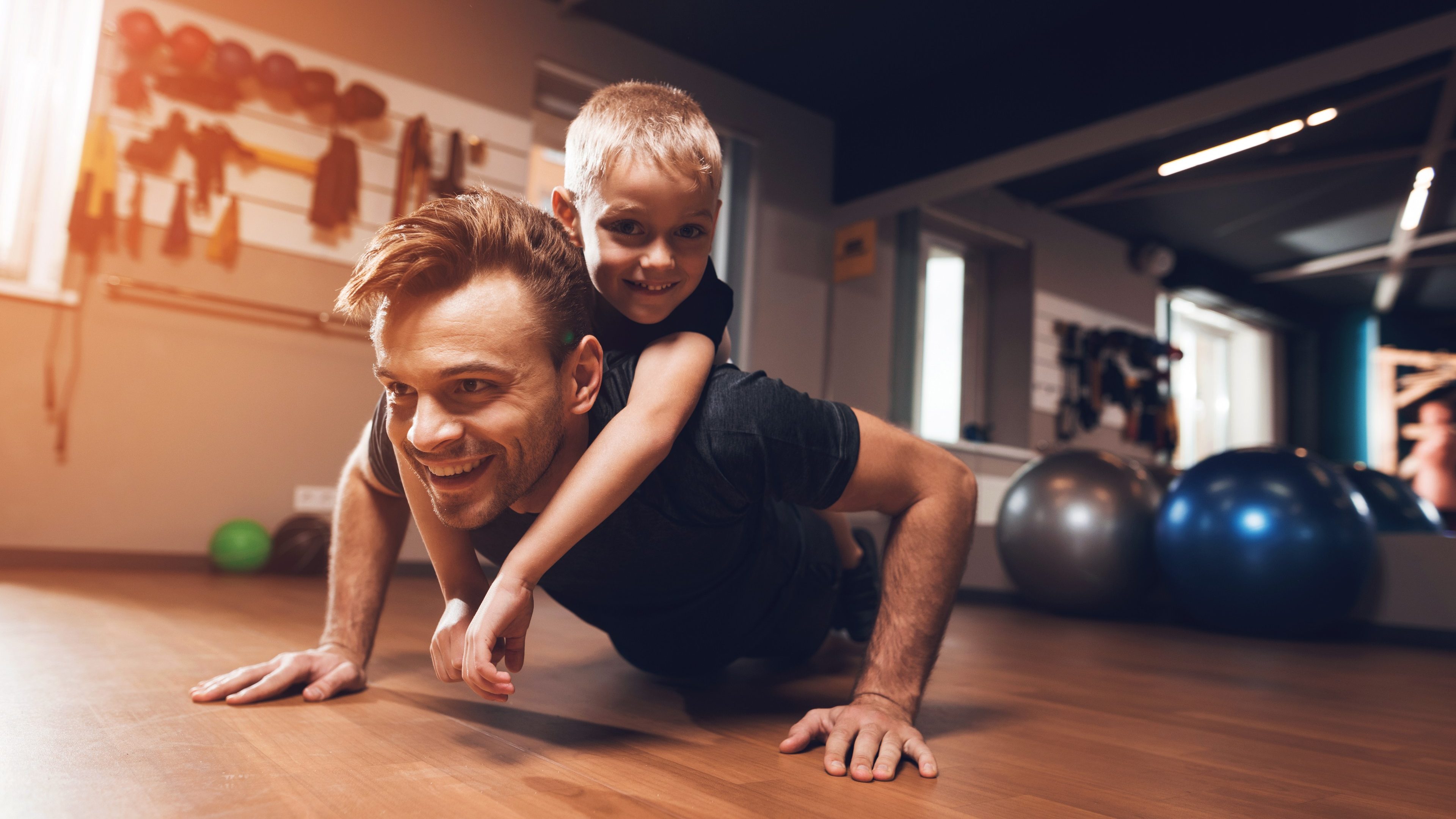 Father and son in the gym. Father and son spend time together and lead a healthy lifestyle. Man and boy are working out. Father and son are doing exercise.
