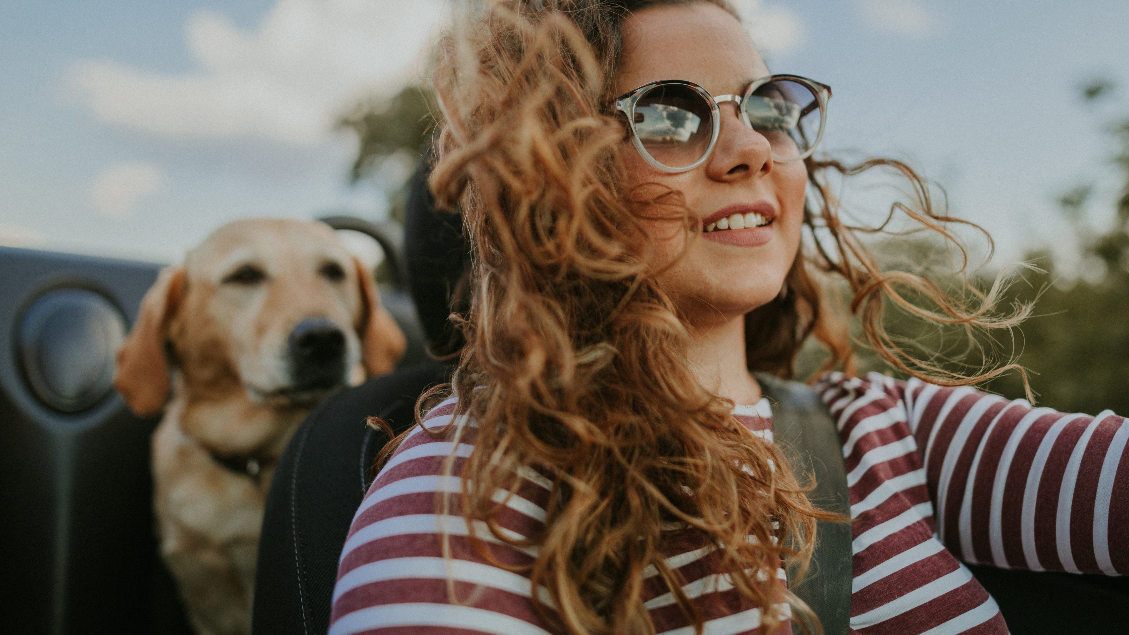 Young woman traveling with her dog in convertible