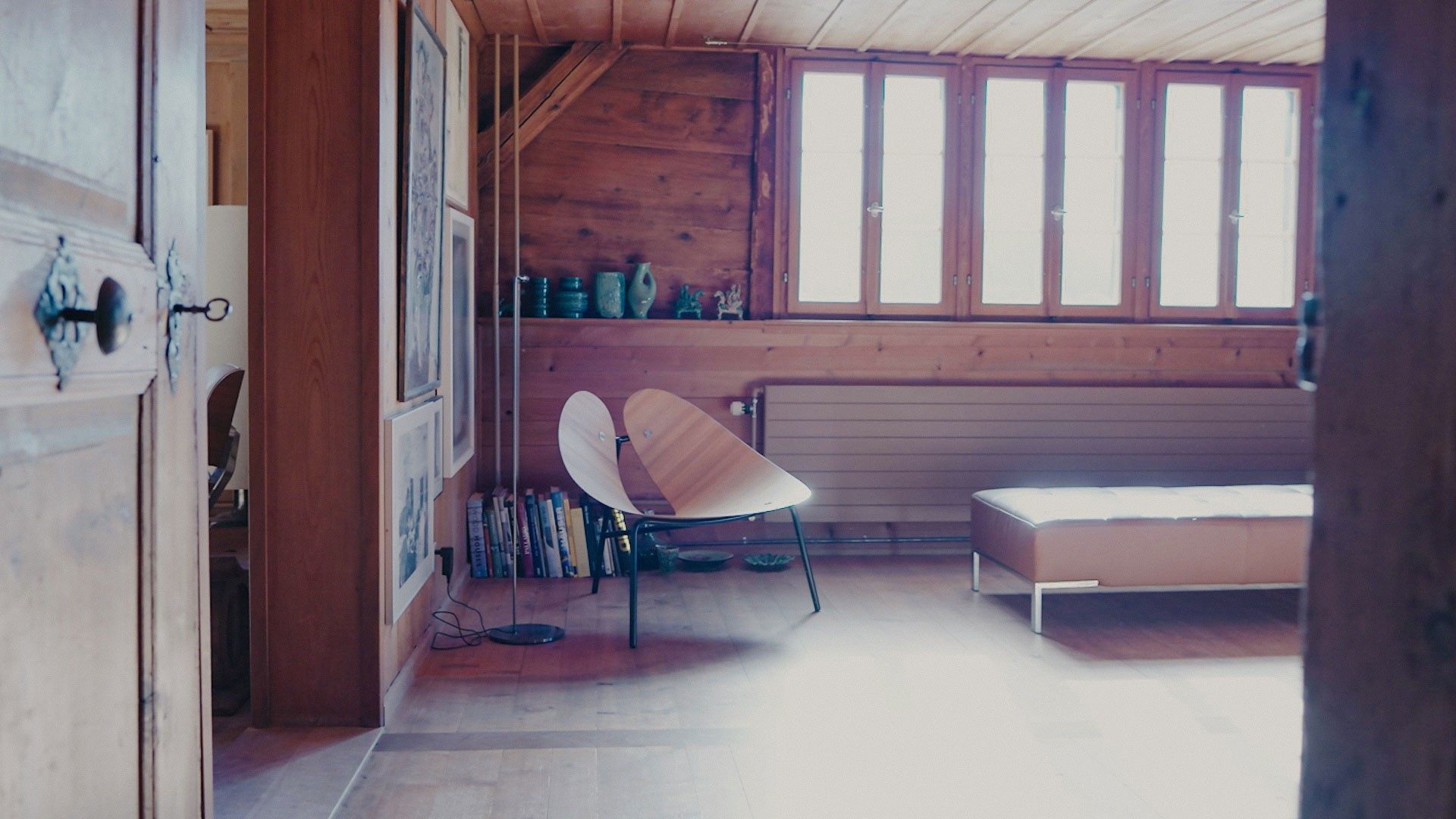 Ein moderner Stuhl steht in einem Raum, der holzgetäfelt ist. 