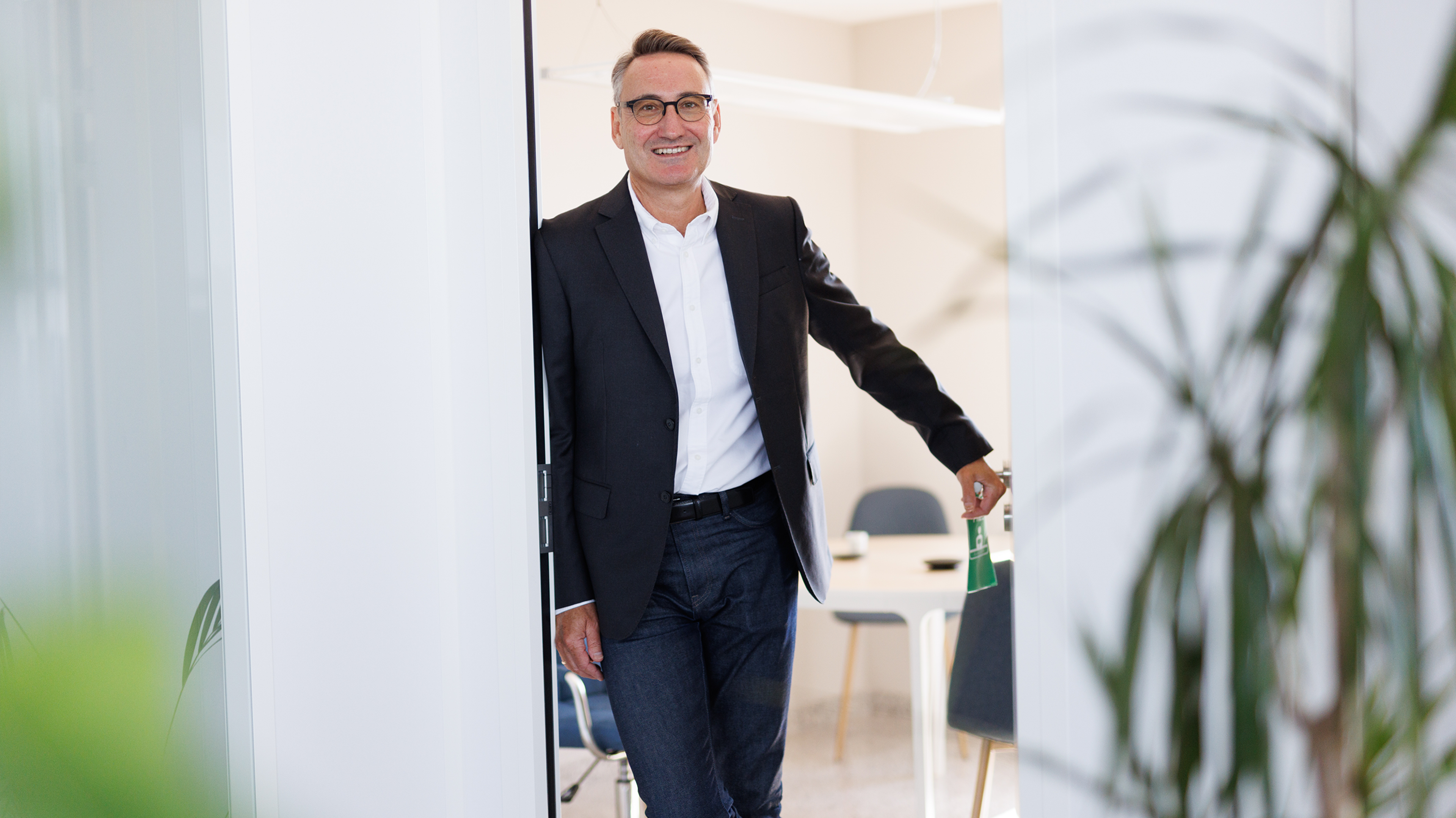 Ein Mann namens Luiggino Torrigiani, ein Start-up-Berater, lehnt entspannt an der Tür eines modernen Büros. Er strahlt Selbstbewusstsein und Erfahrung aus und scheint bereit zu sein, jungen Unternehmern mit Rat und Tat zur Seite zu stehen.