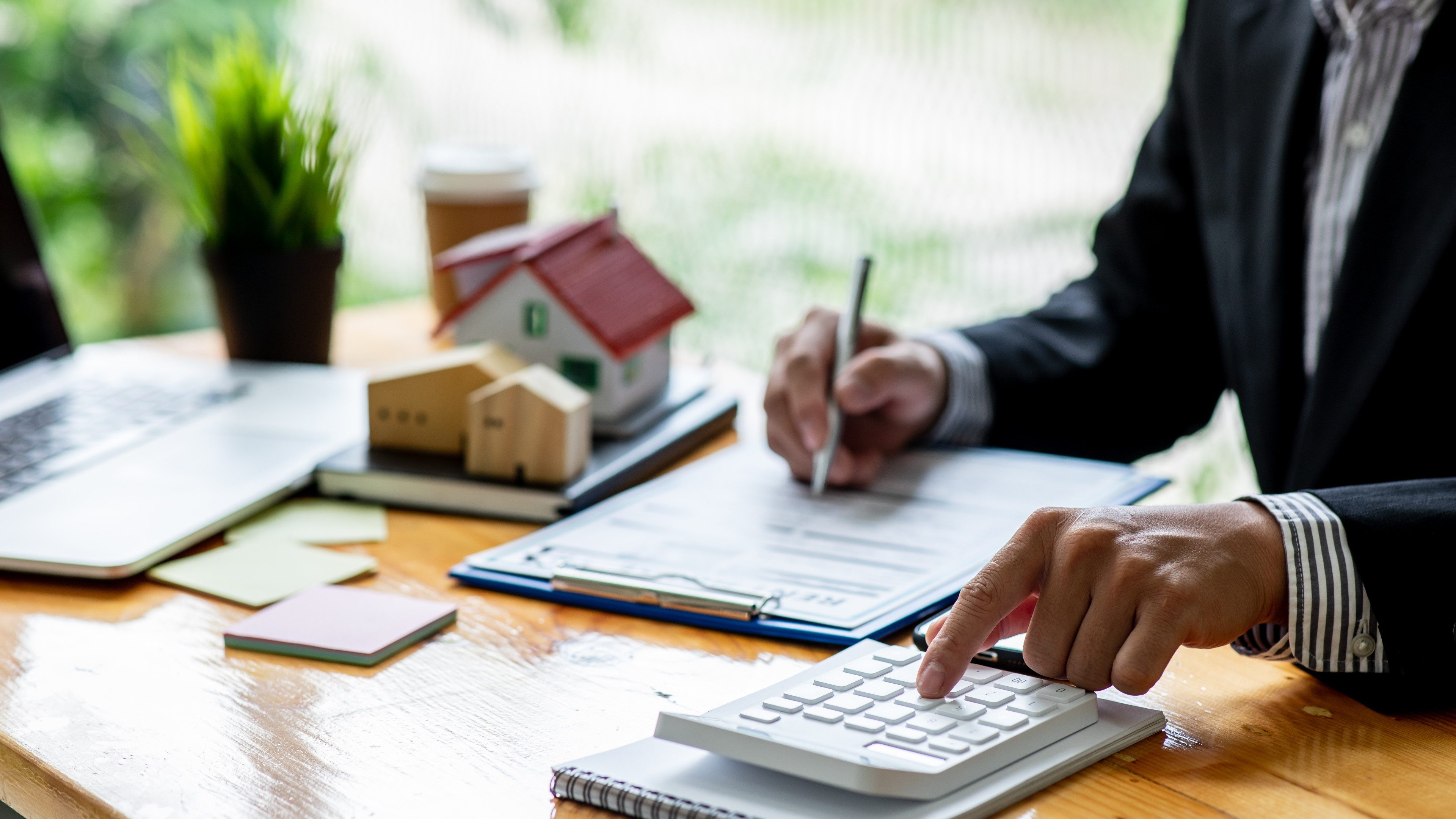 Close up house model with business man signs a purchase contract or mortgage for a home,  buy and sell home  insurance concerning mortgage loan Real estate concept.