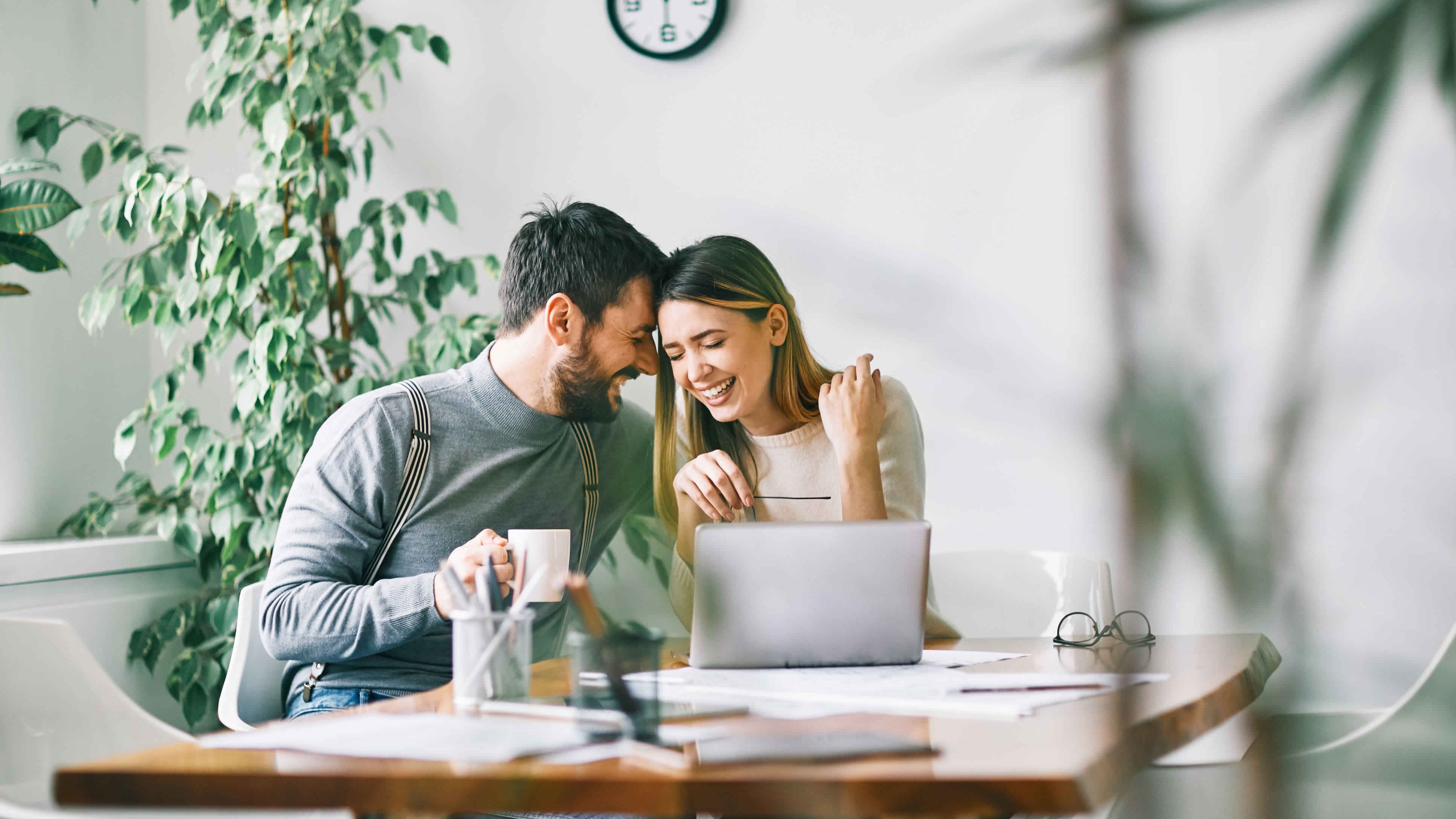 Smiling couple working at home or in the office with laptop