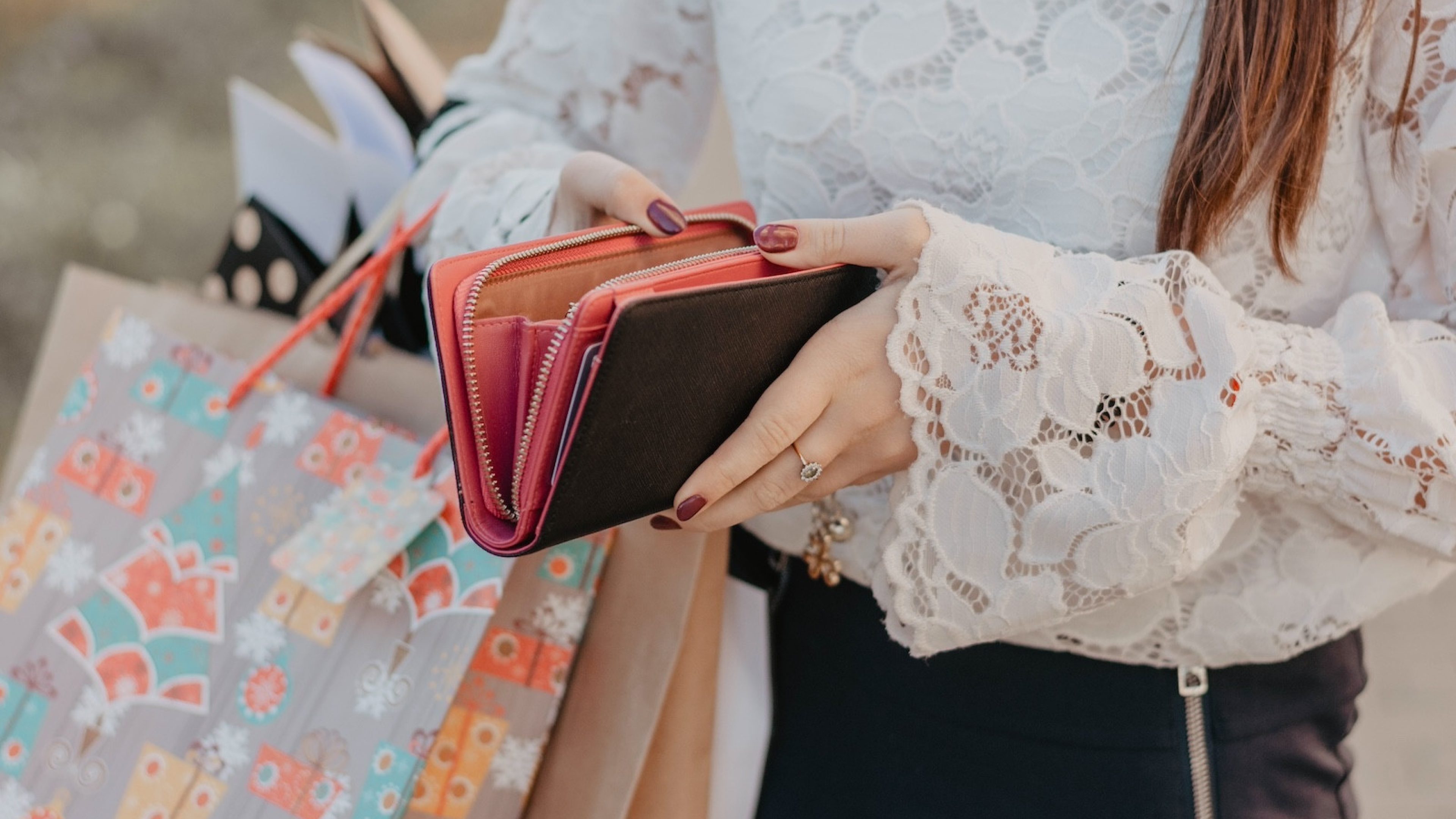 Woman with shopping bags holding a leather wallet. Concept of epmty purse after black friday sale