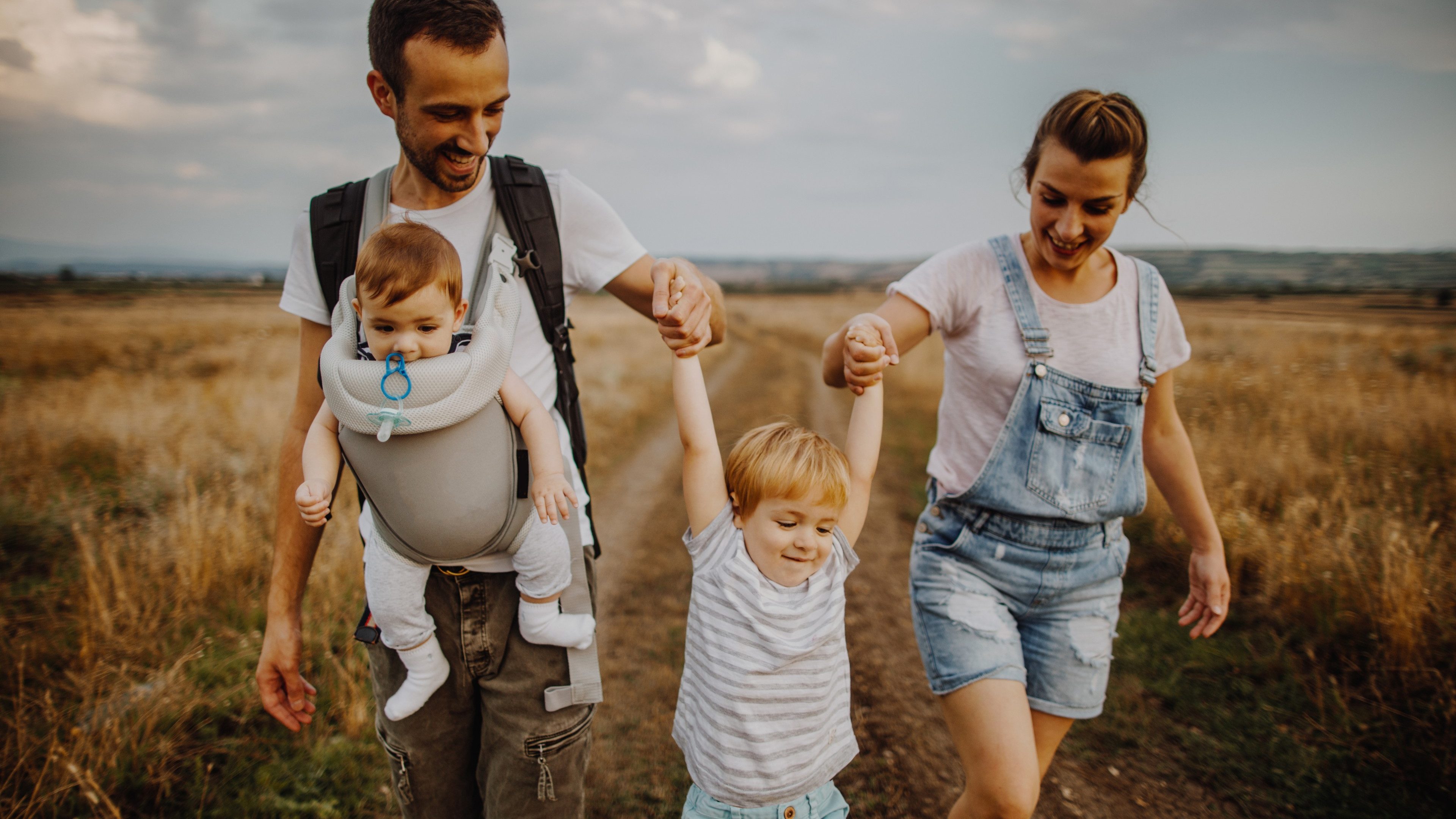 Photo of a young loving family who enjoys spending their time together, outdoors