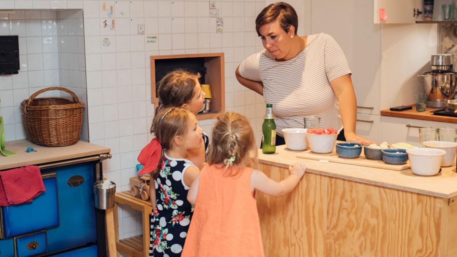 Mutter mit Kindern in der Küche, sie bereiten gemeinsam eine Mahlzeit vor.