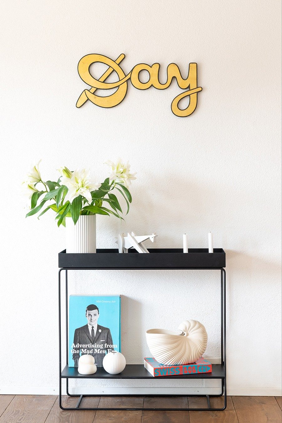 Der Schriftzug «Day» hängt über einem schlichten Sideboard.