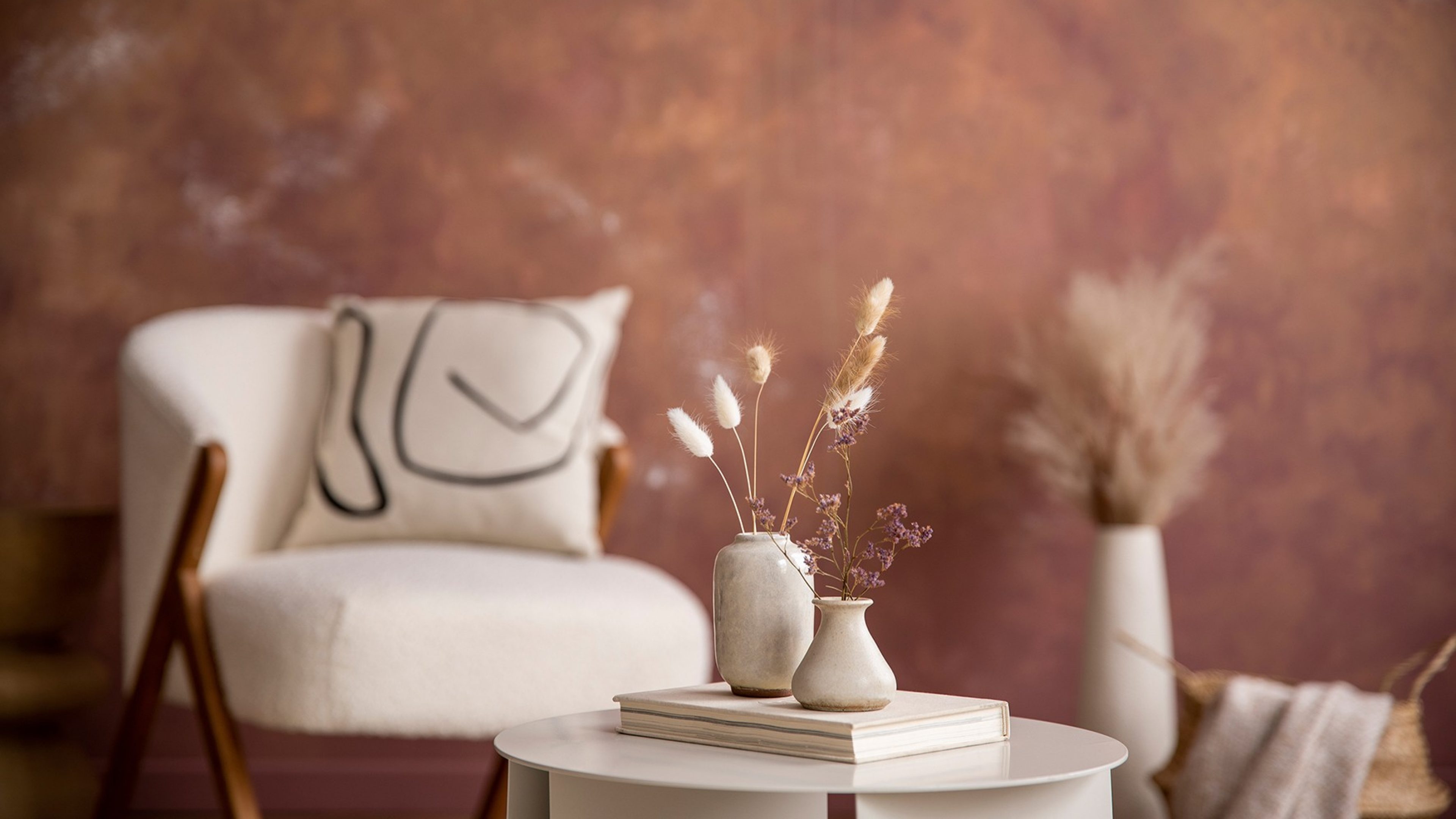 Gemütlicher Wohnraum mit Sofa und Pflazen, in hellen Naturfarben eingerichtet. 