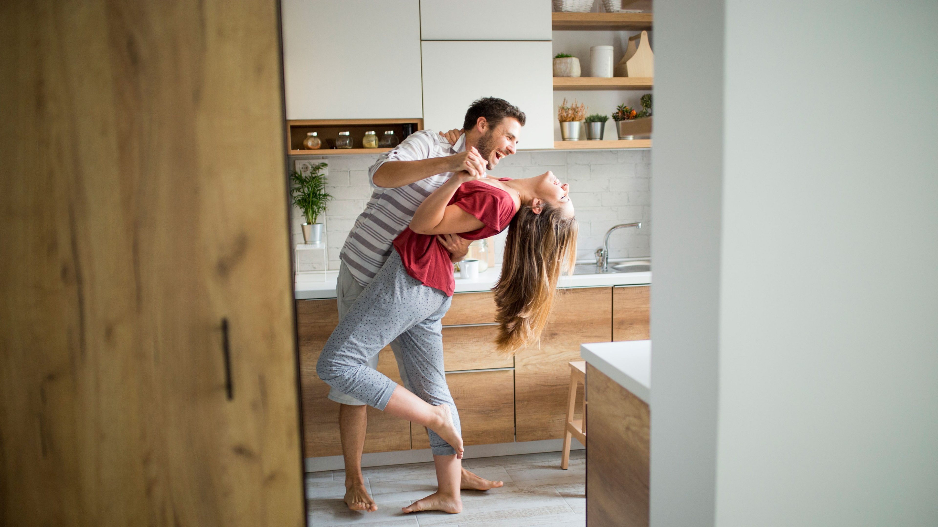 Ein Paar tanzt in der Küche des Eigenheims.
