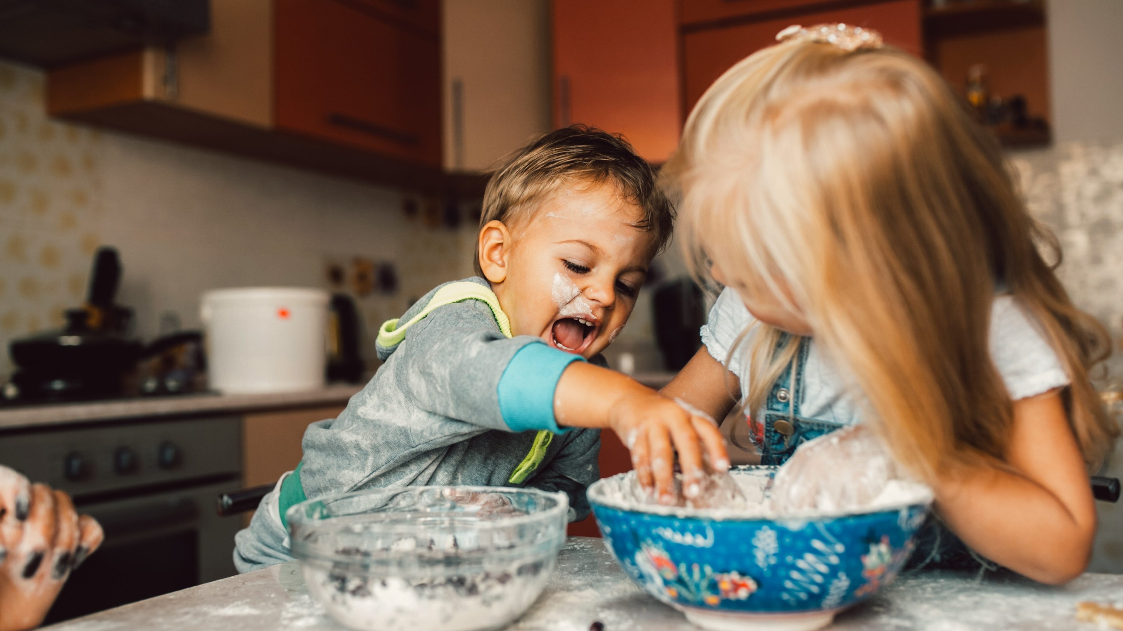 Kids is playing with flour in the kitchen