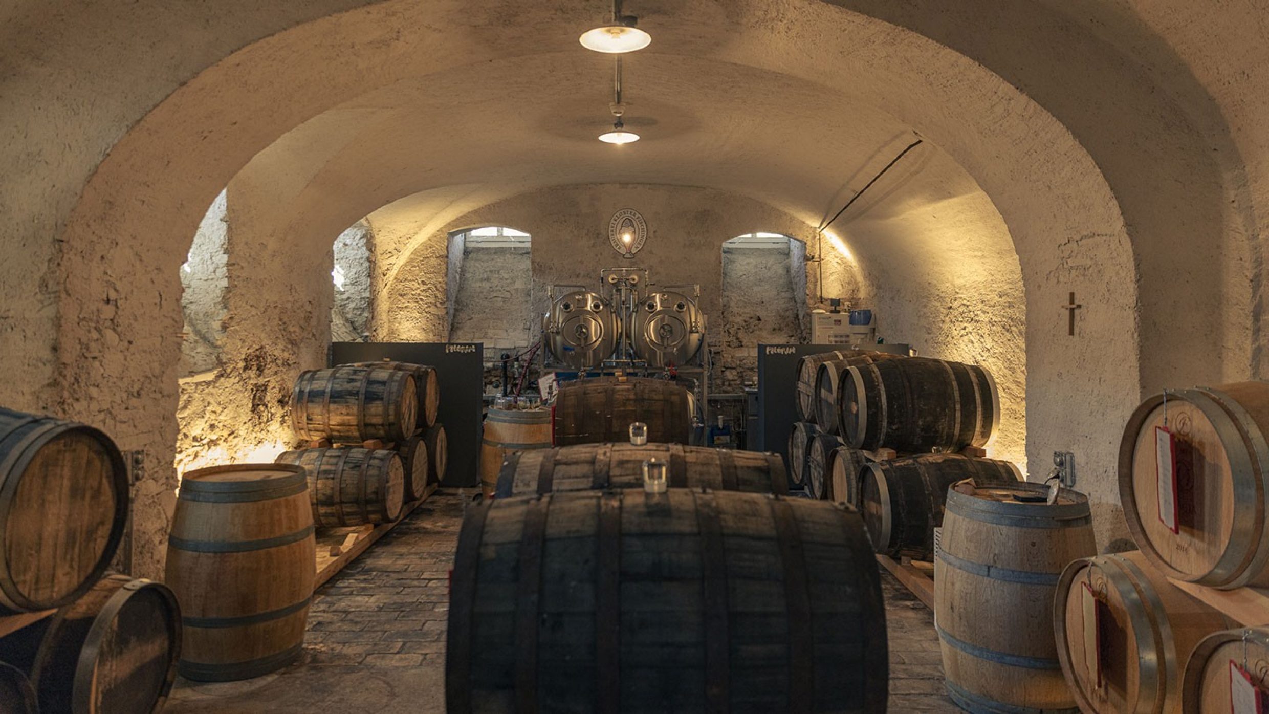 Dans l’ancienne cave de l’abbaye, derrière des murs de trois mètres d’épaisseur, les grands crus mûrissent en barriques pendant plusieurs mois, voire plusieurs années. Ces barriques ont entre 20 et 30 ans et possèdent une histoire:  elles ont servi de fûts à vin dans des caves de Bourgogne, puis de fûts de sherry en Espagne, de fûts à whisky en Ecosse ou de fûts à rhum ou à tequila aux Caraïbes.