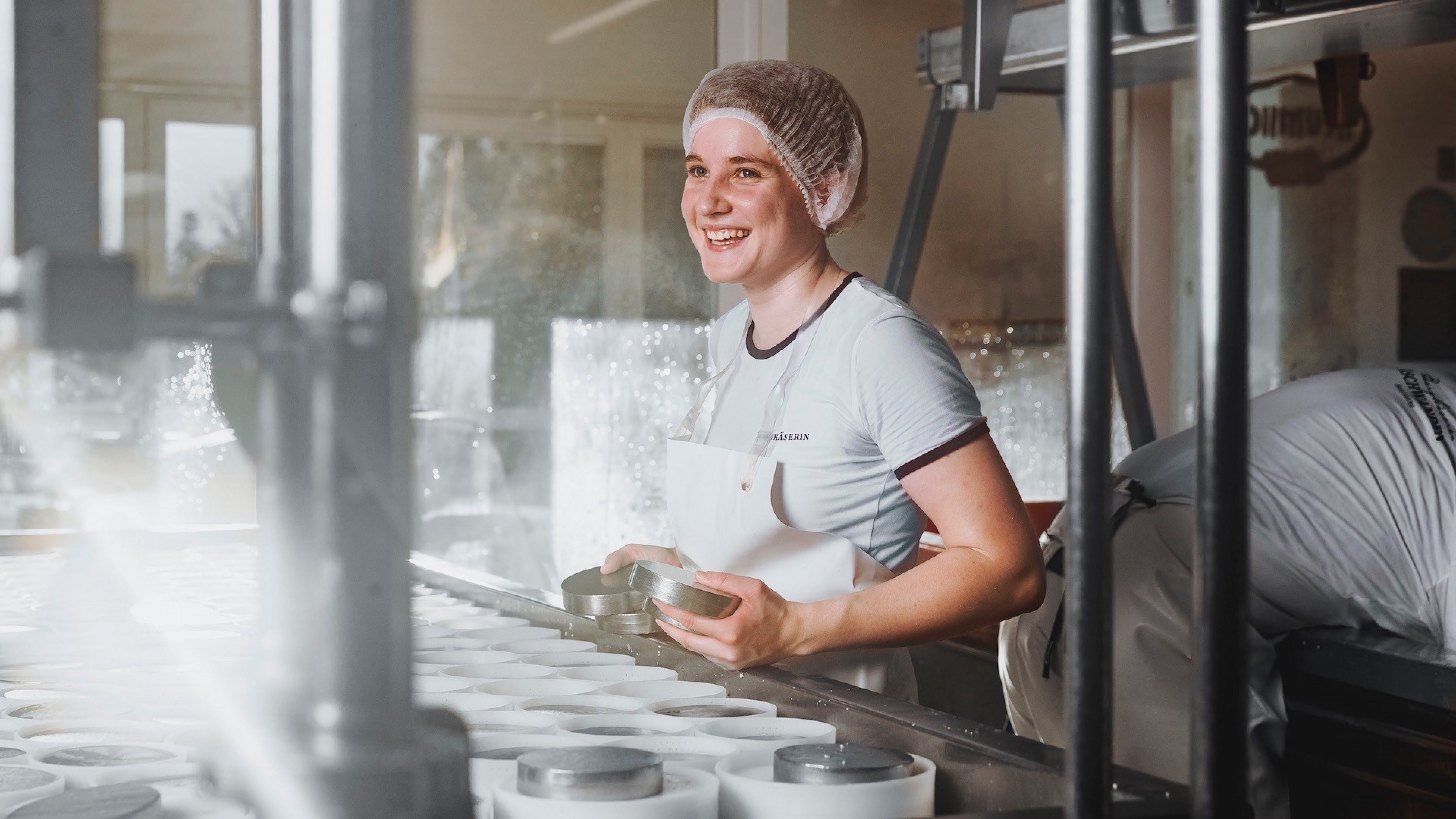 Une fromagère motivée travaille à la fromagerie et rayonne.