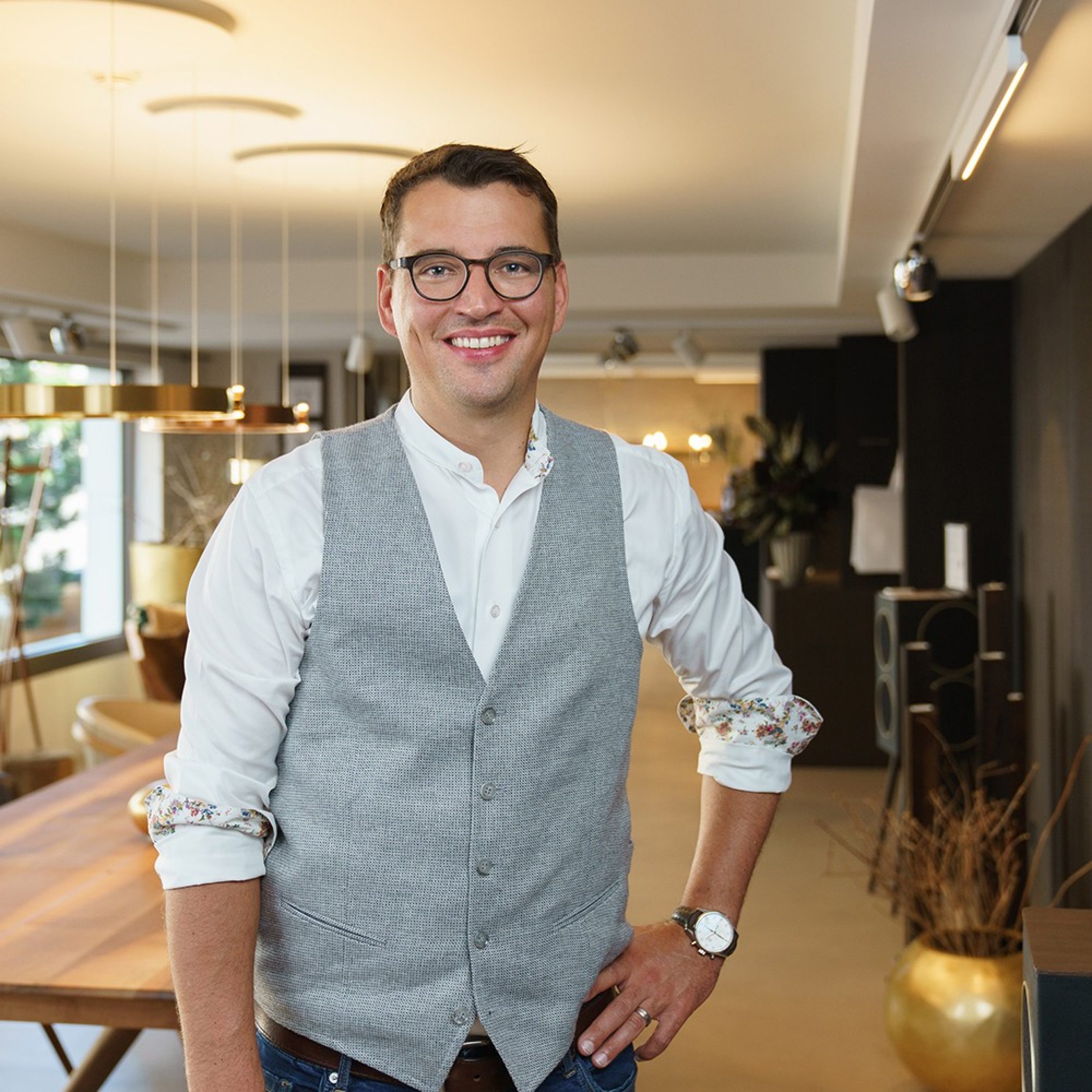 Homme debout dans un showroom, souriant.