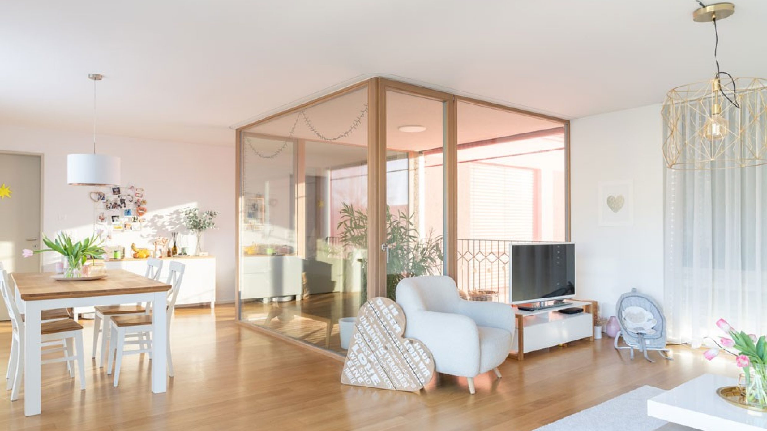 Des baies vitrées s’alignent autour d’une loggia qui se présente tel un cube de verre dans le salon.