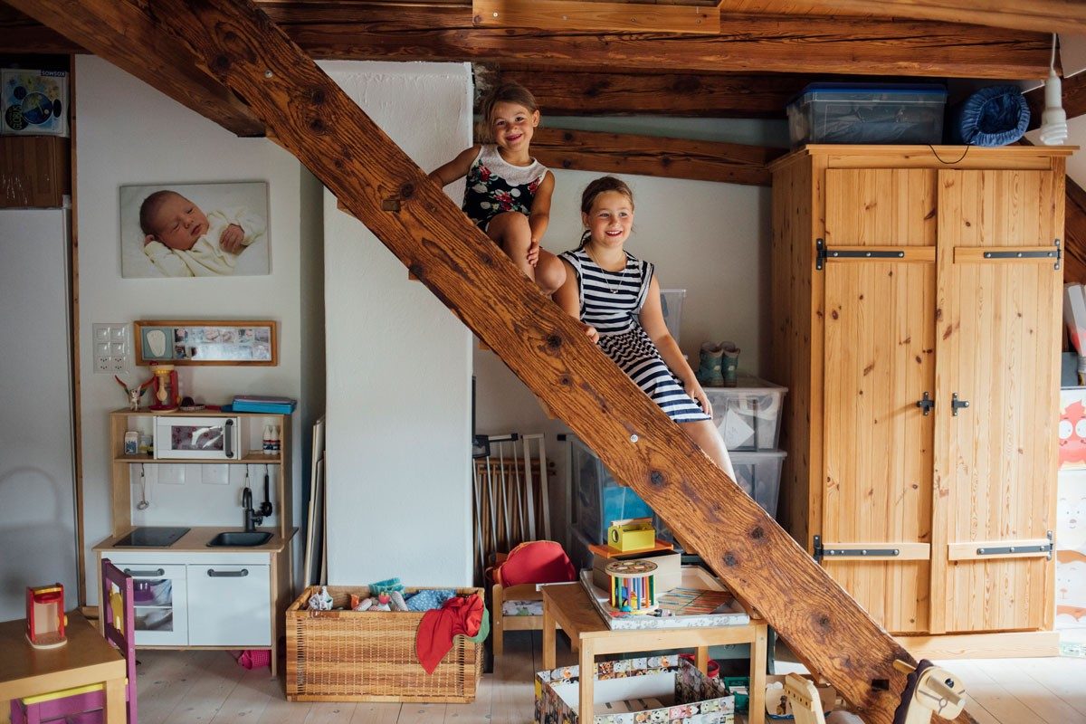 Deux petites filles assises sur un escalier en bois.