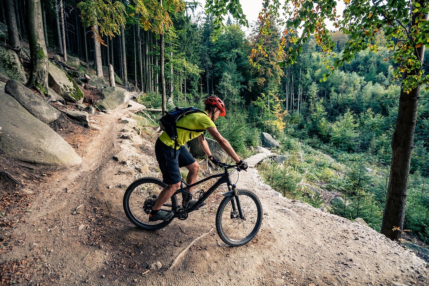 Mountain biker riding on bike in autumn inspirational mountains landscape. Man cycling MTB on enduro trail track. Sport fitness motivation and inspiration.