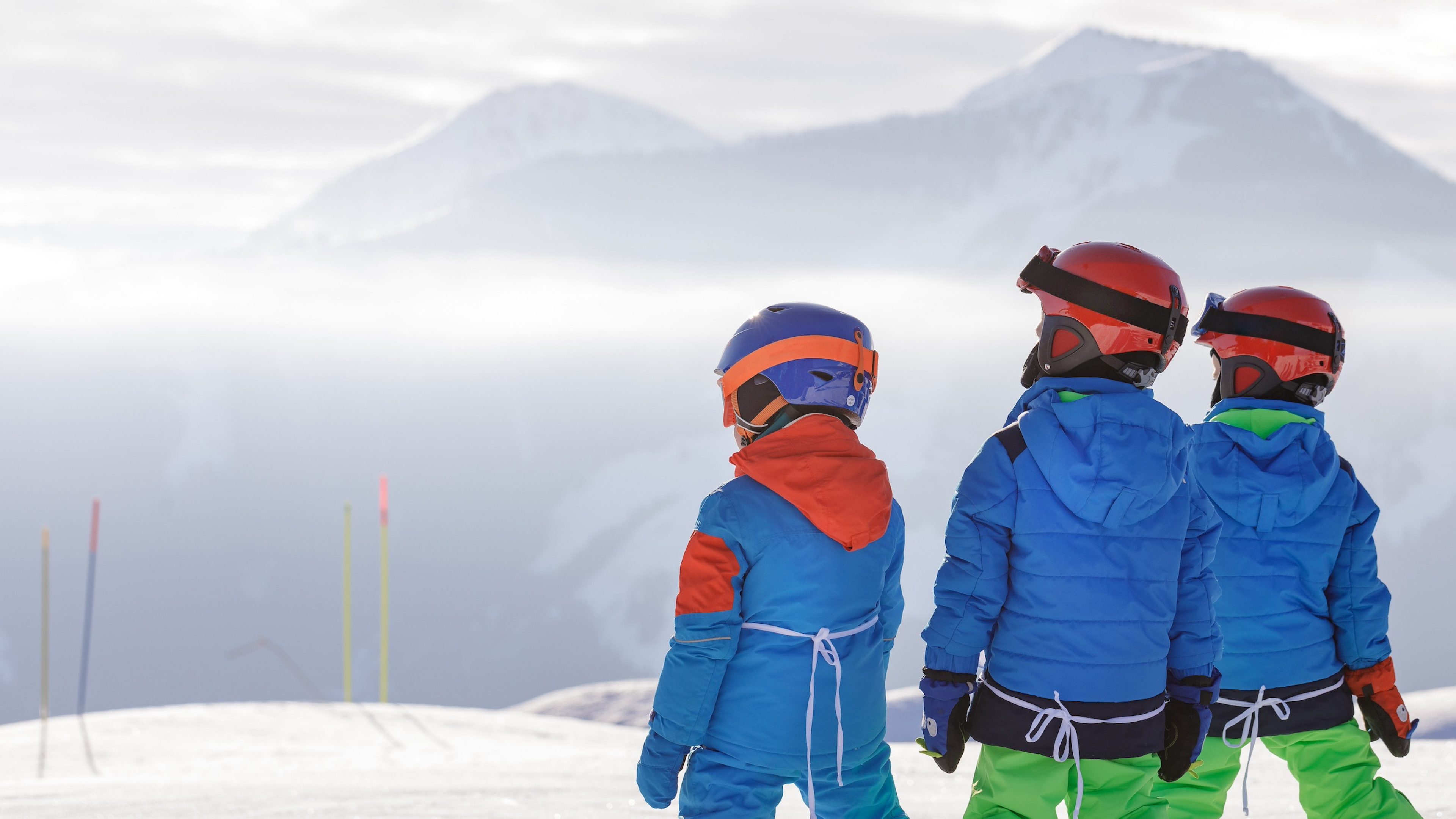 Bambini in piedi in cima alla pista da sci.
