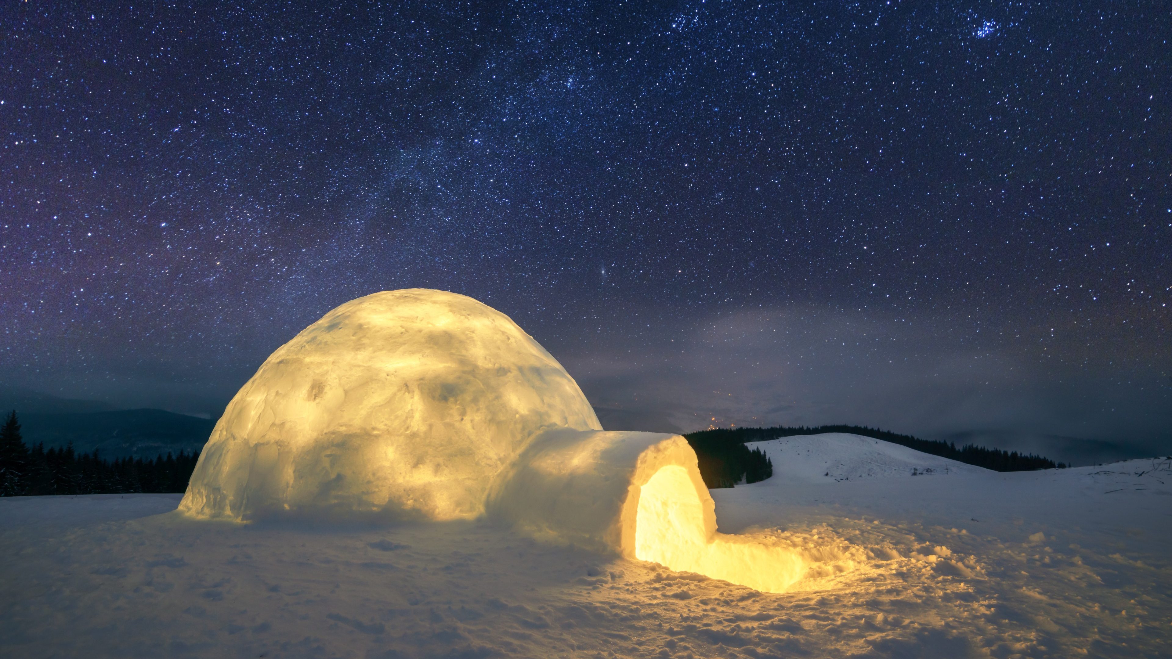 Fantastic winter landscape glowing by star light. Wintry scene with snowy igloo and milky way in night sky