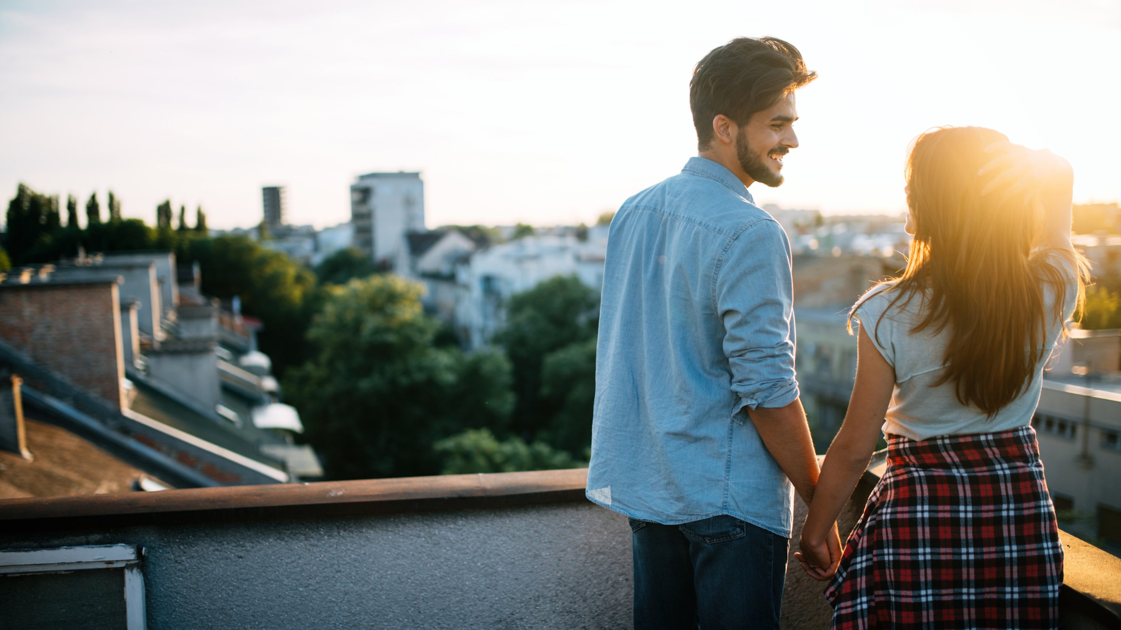 Beautiful couple in love enjoying at sunset in a terrace