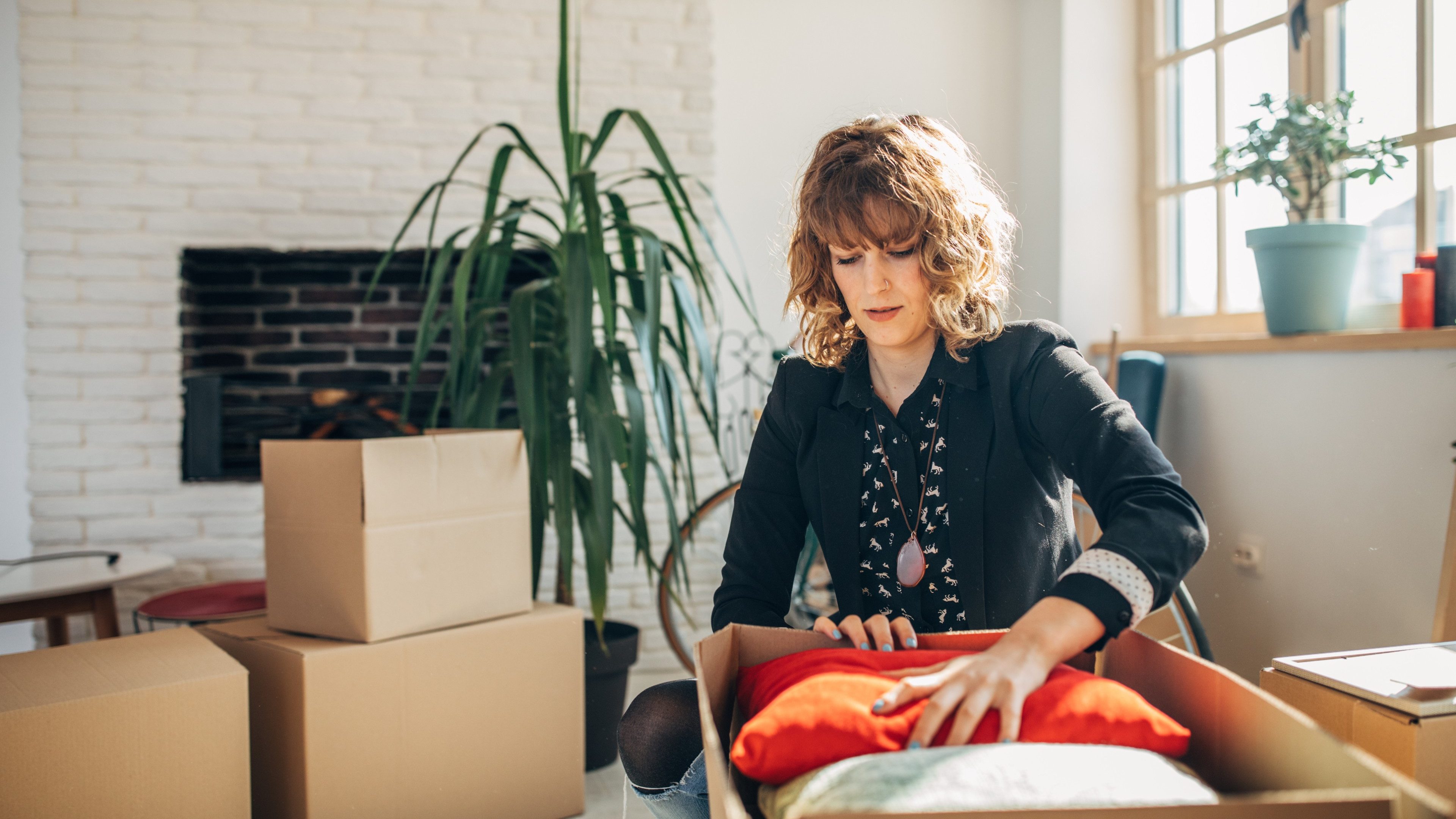 One woman, young lady moved into her new apartment, unpacking boxes alone.