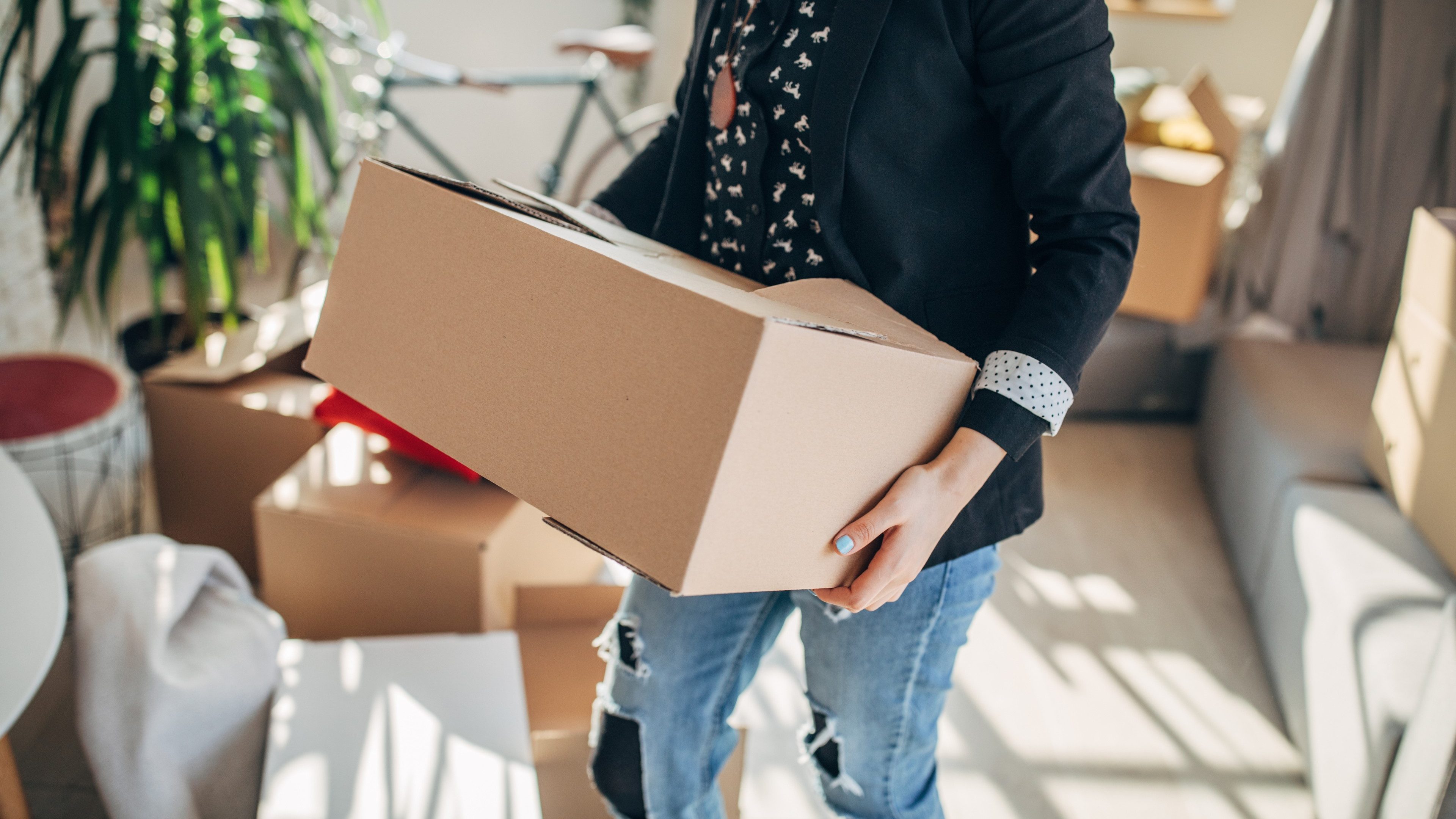 One woman, young lady moved into her new apartment, unpacking boxes alone.